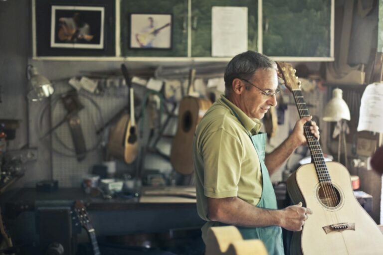 Photo of Man Holding Acoustic Guitar